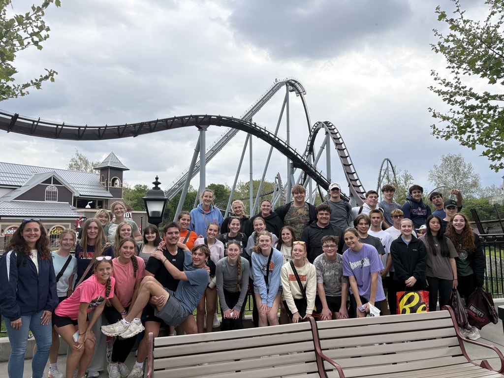 high school students at amusement park in from of roller coaster