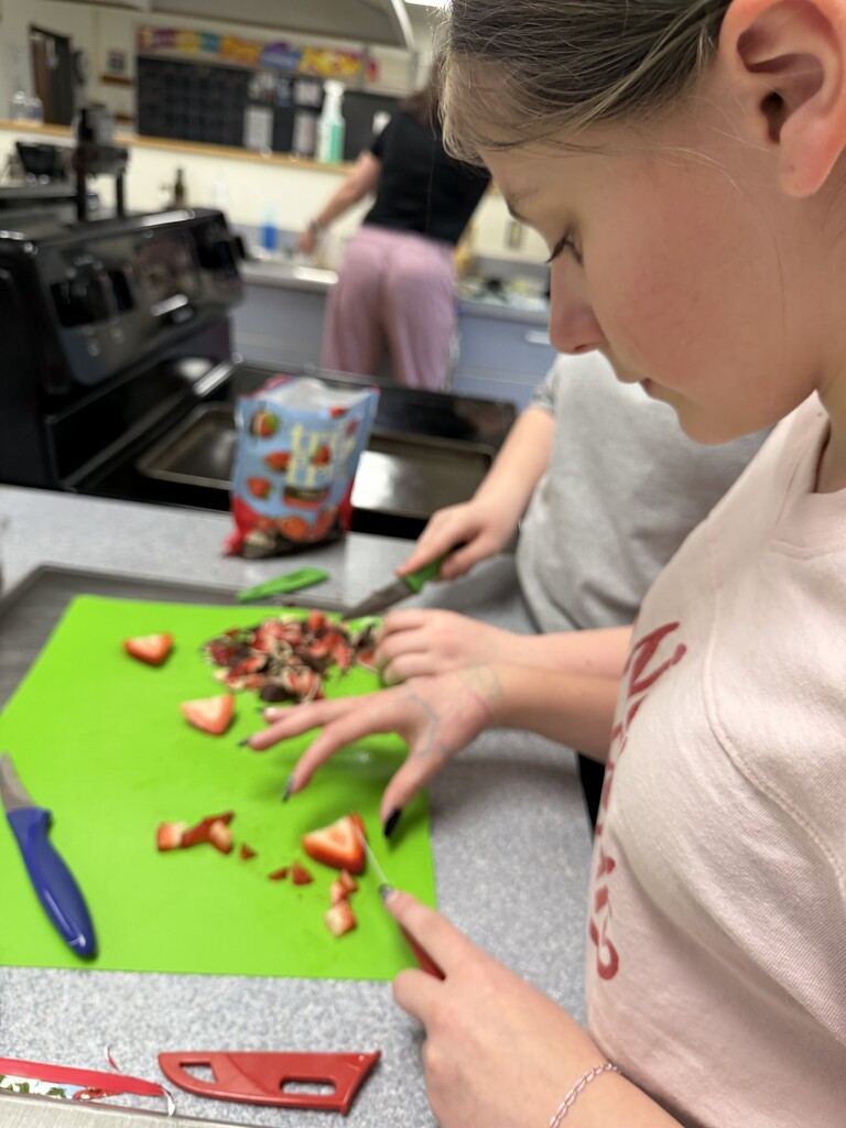 student chopping fruit