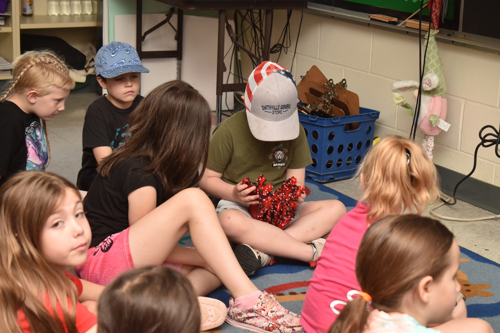 students in classroom sitting on floor