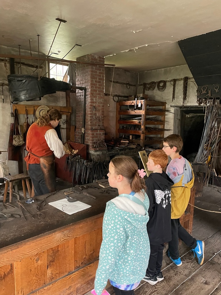 elementary students in old time village blacksmith shop