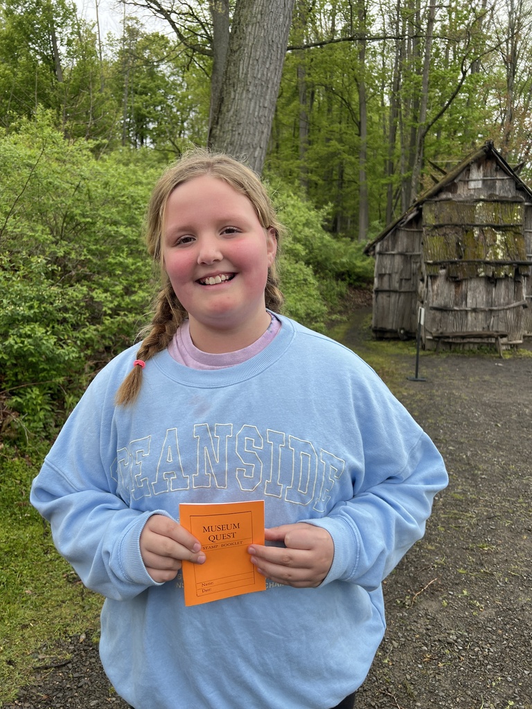 elementary student in from of old home