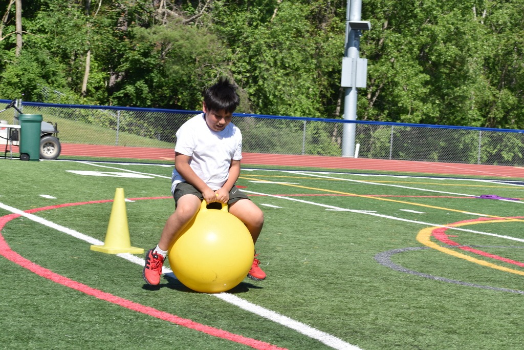 student bouncing on ball