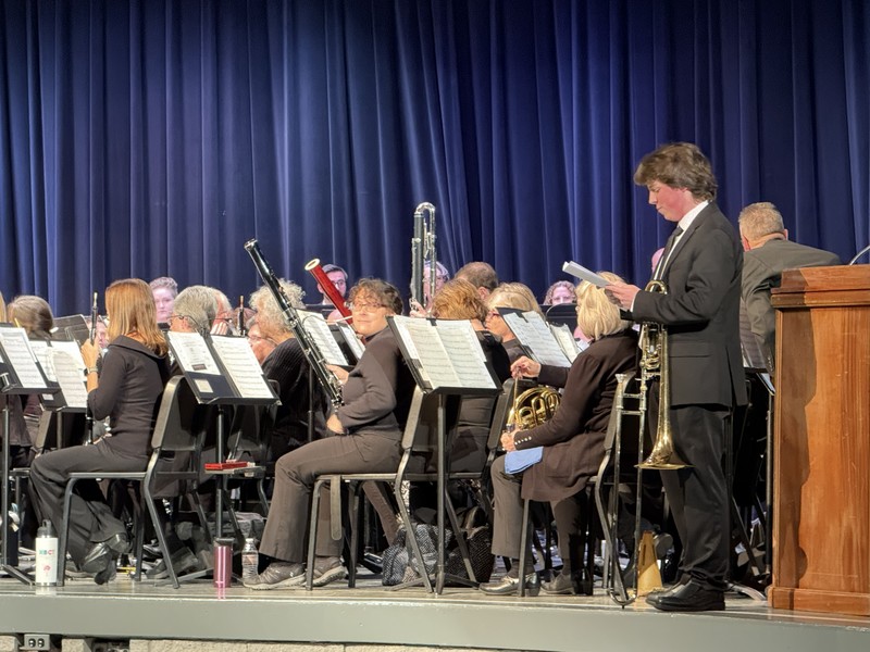 Student and concert band on stage with instruments
