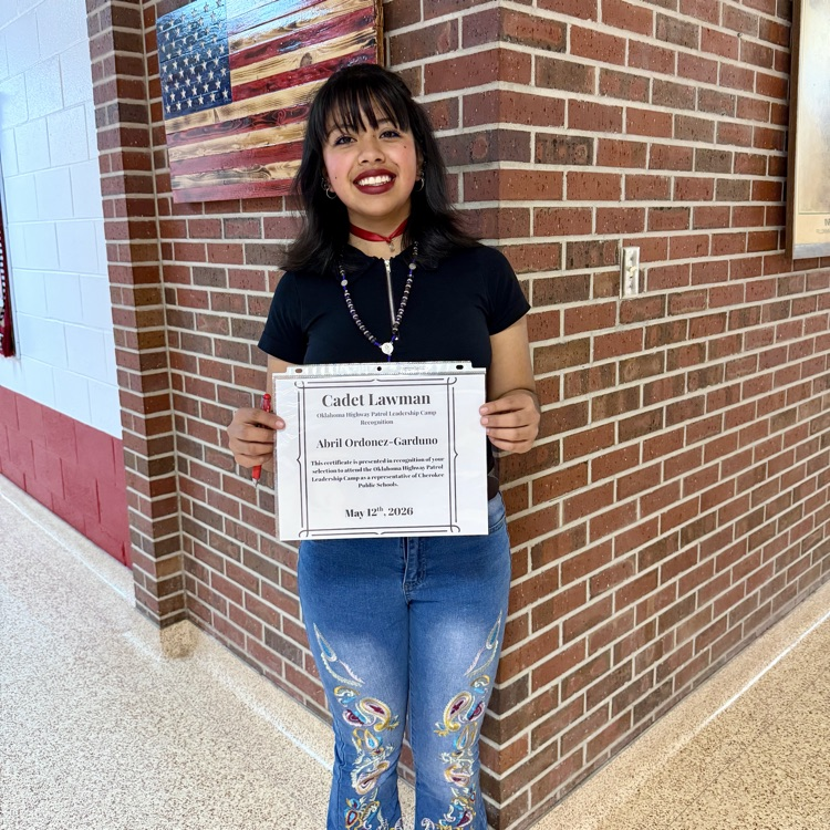 photo of a female student holding a certificate for being accepted into the Cadet Lawman Leadership camp