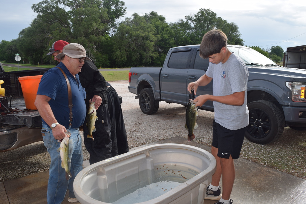 3 individuals holding fish