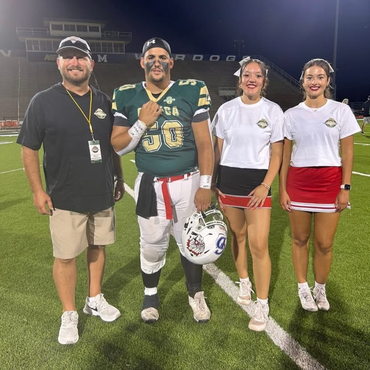 photo of Coach Schanbacher on a football with 3 recent Cherokee graduates  