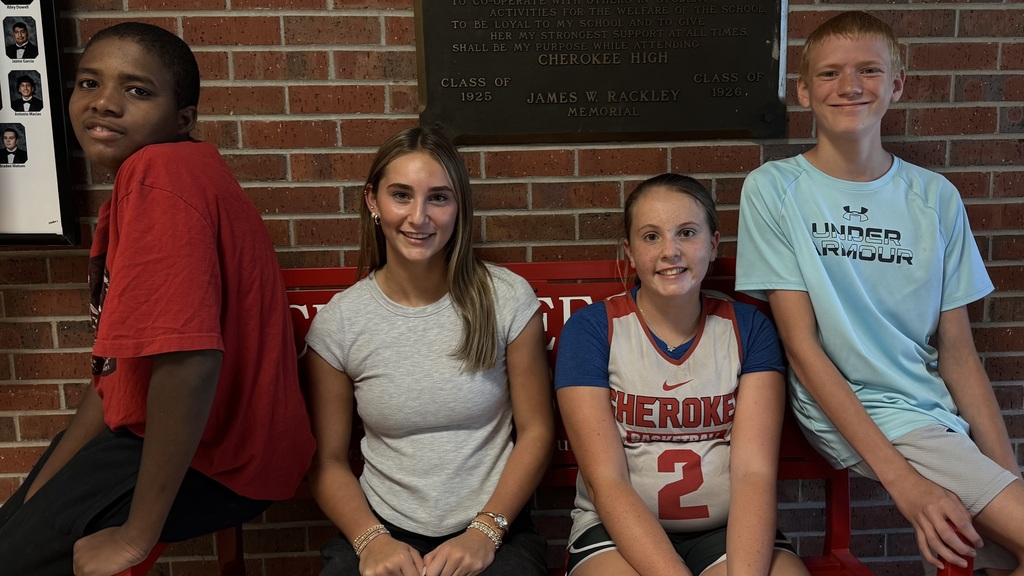 Photo of four HS students seating on a bench.