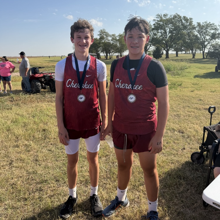 2 students in red uniforms at cross country meet