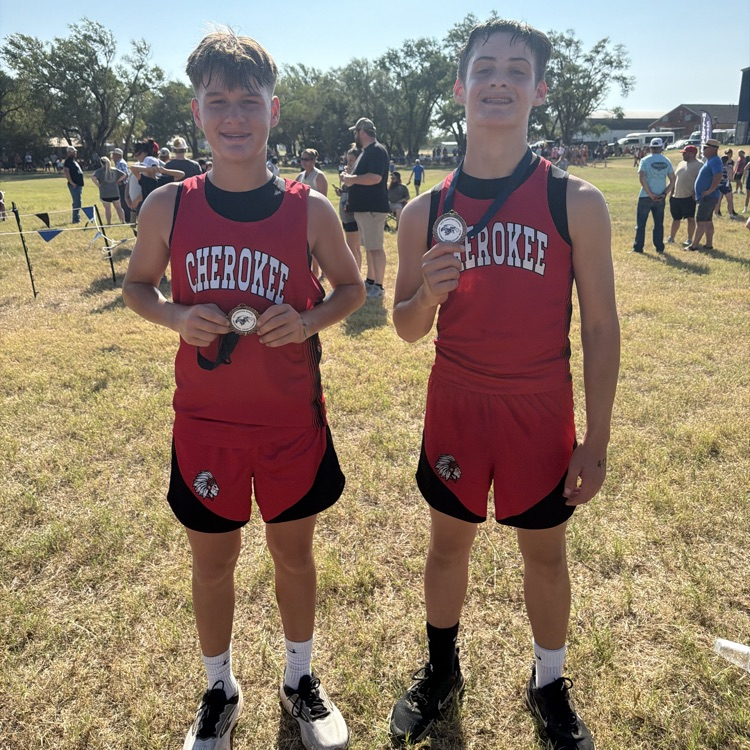 2 students in red uniforms at cross country meet