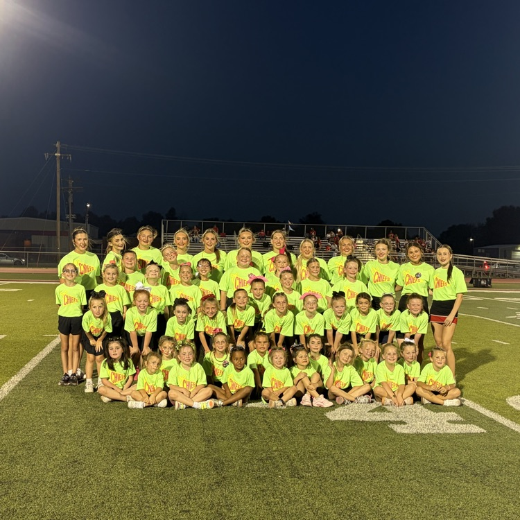 group of students in neon green shirts on a football field