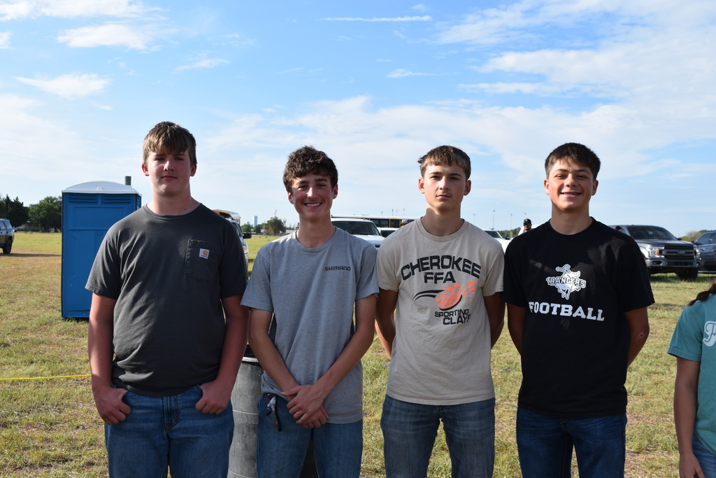 Picture of 4 students standing in a grassy area.