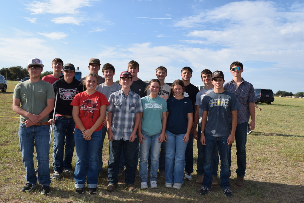 Group picture of students standing in a grassy field.
