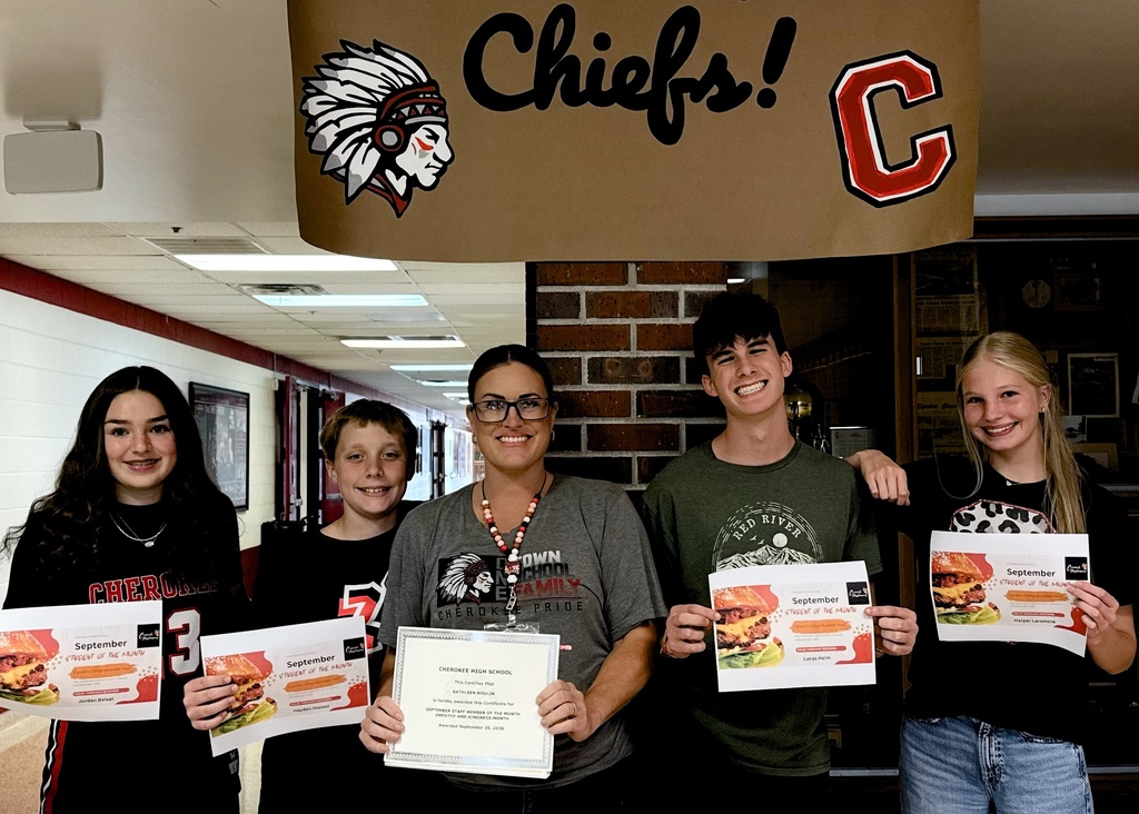 Photo of 4 students and 1 adult in the hallway.  All are holding certificates for student and staff of the month.