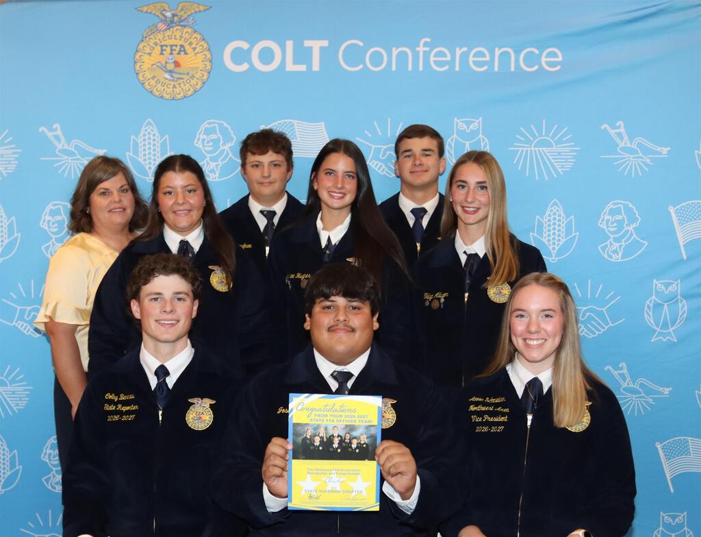Group picture of the FFA officers and advisor standing in front of a blue background that says COLT Conference.