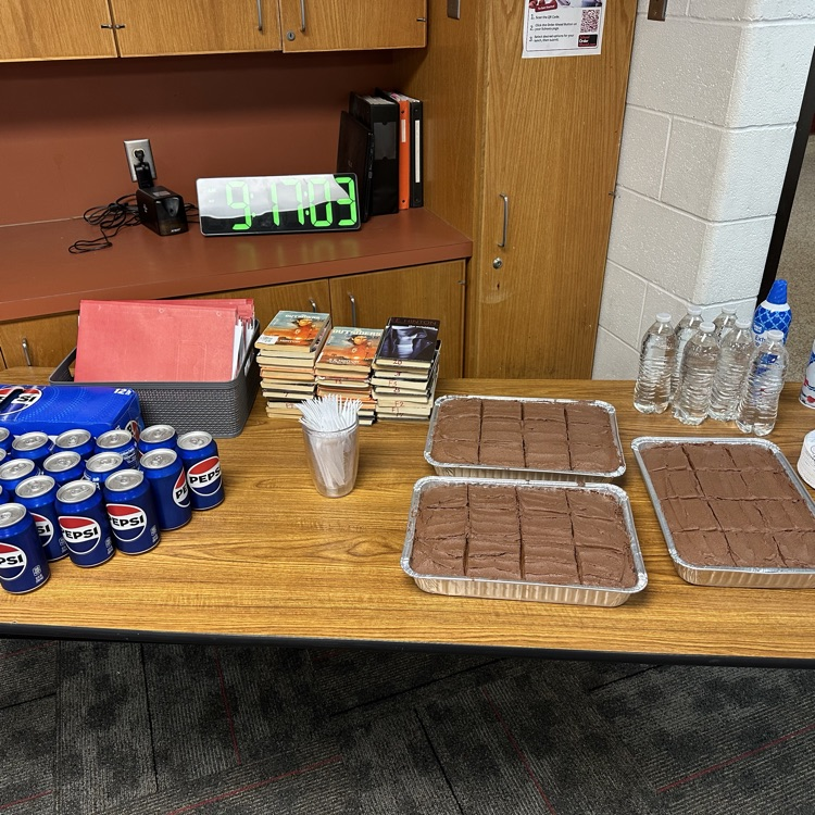 picture of a table in a classroom with Pepsi and chocolate cake