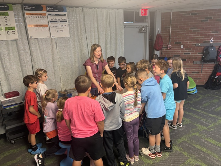 photo of students in a classroom gathered around a table