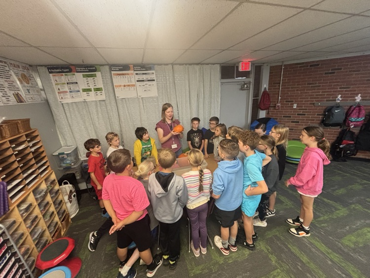 photo of students in a classroom gathered around a table