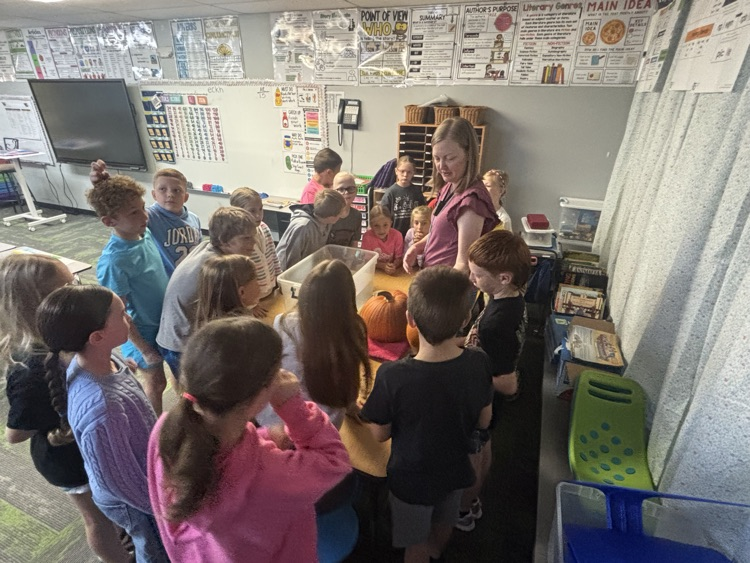 photo of students in a classroom gathered around a table