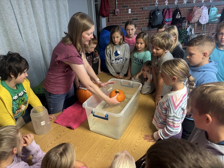 photo of students in a classroom gathered around a table