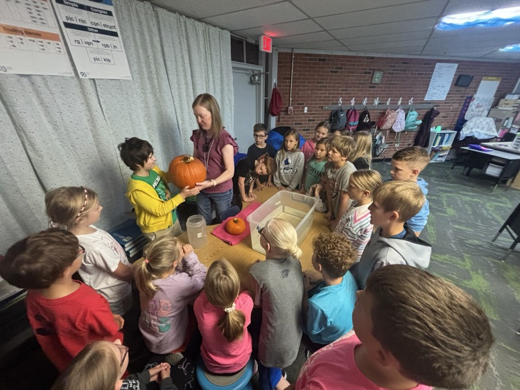 photo of students in a classroom gathered around a table