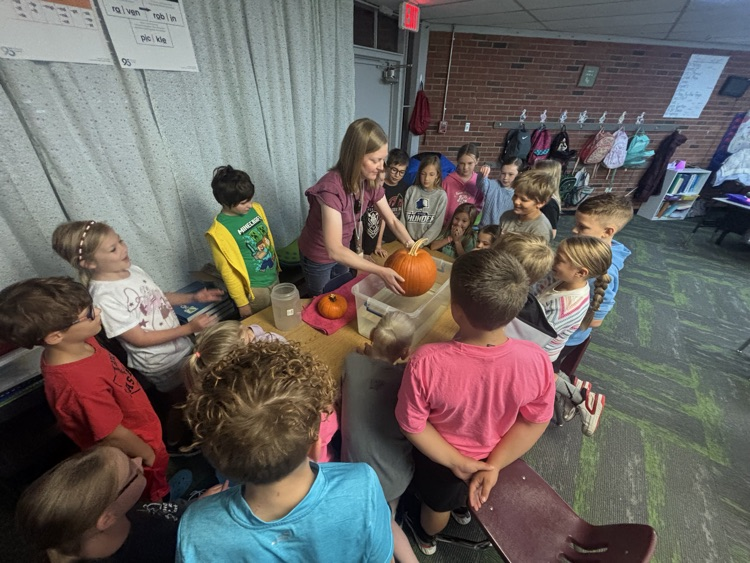 photo of students in a classroom gathered around a table