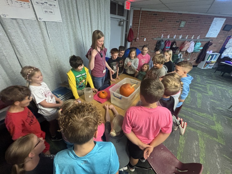 photo of students in a classroom gathered around a table