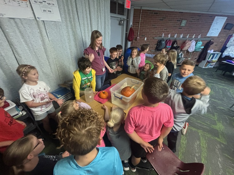 photo of students in a classroom gathered around a table