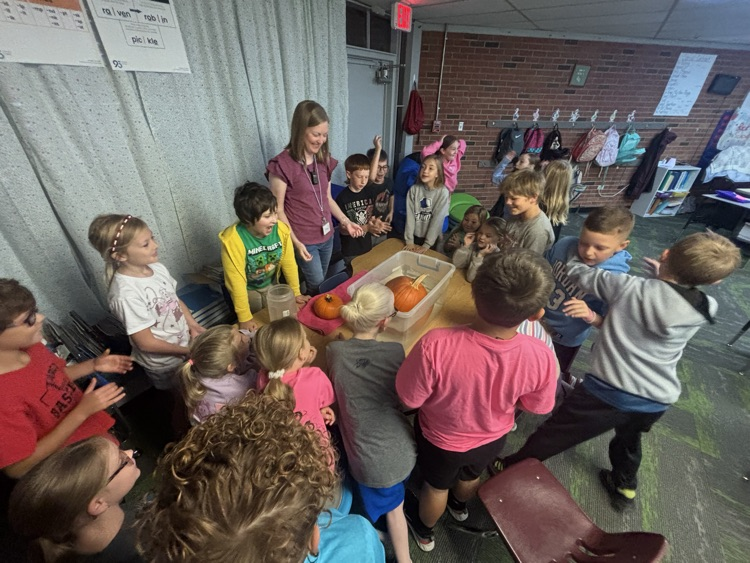 photo of students in a classroom gathered around a table