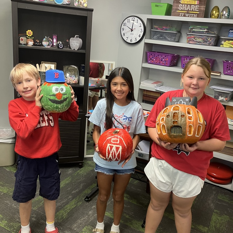 Group of students in a classroom with decorated pumpkins