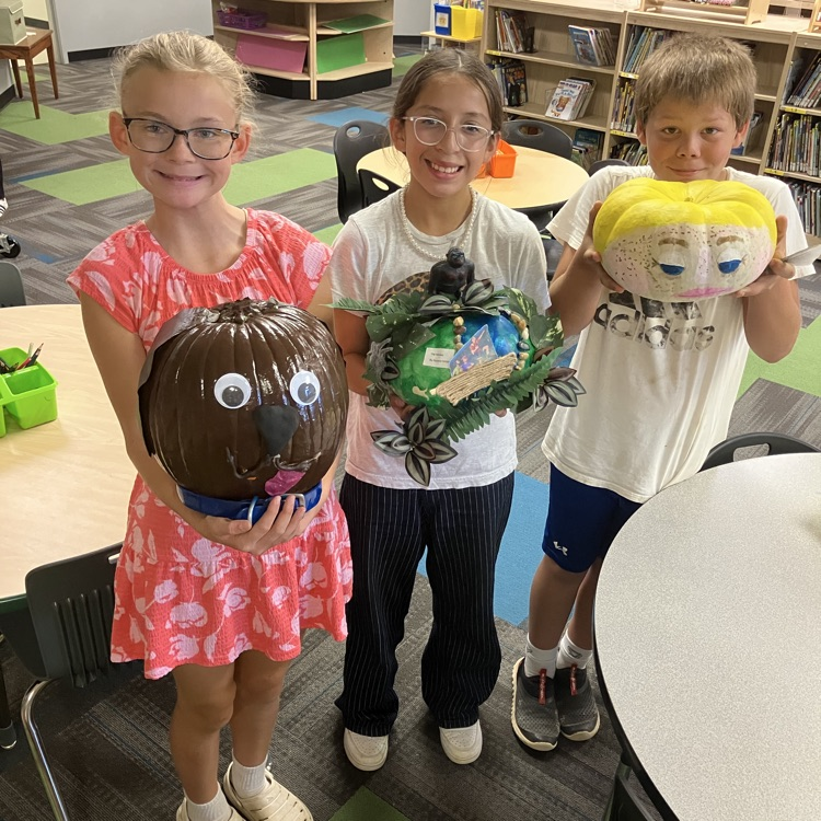 Group of students in a classroom with decorated pumpkins