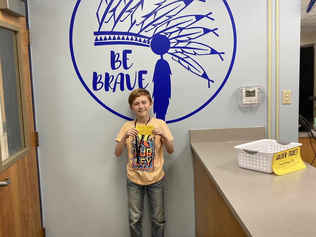 Student with Golden Ticket in front out Be Brave Wall