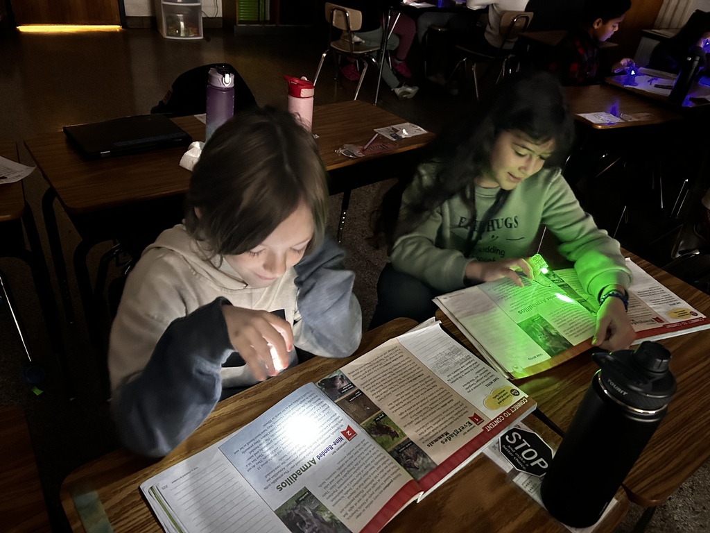 Two students reading with flashlughts