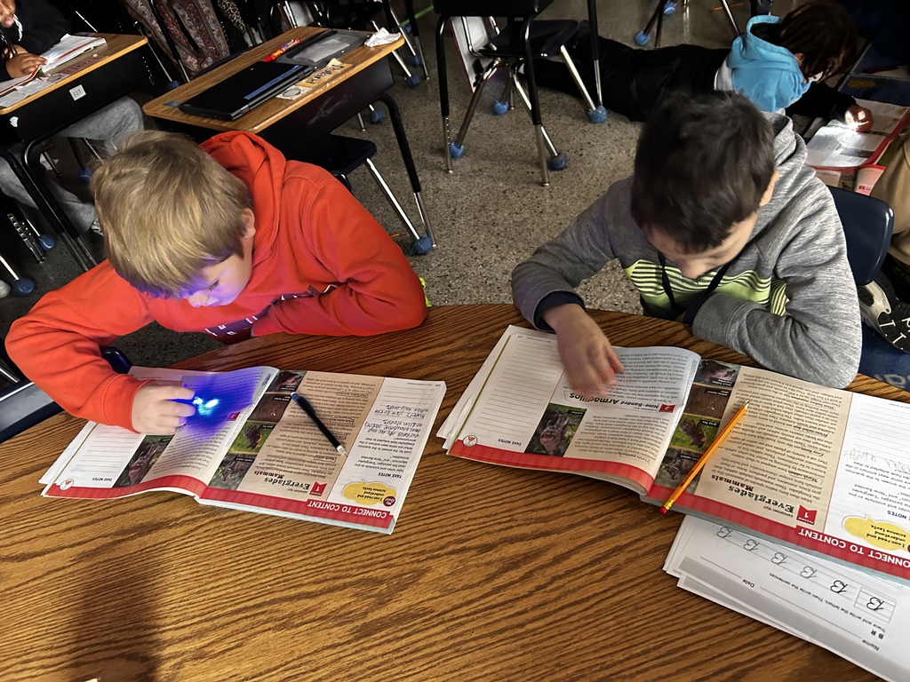 Two students reading with flashlights