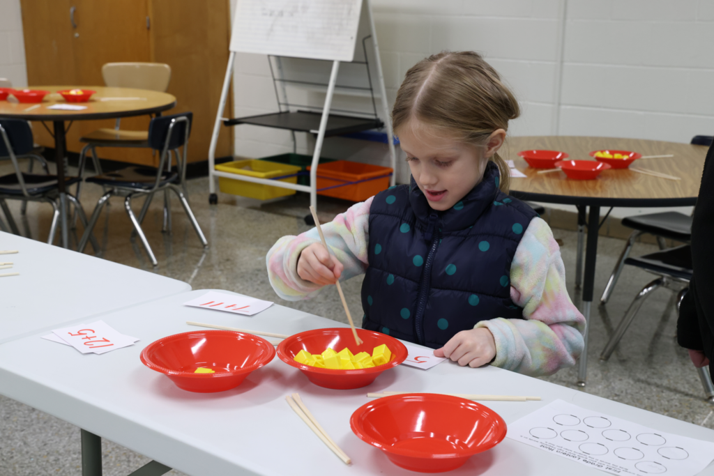 girl using chopsticks to play game