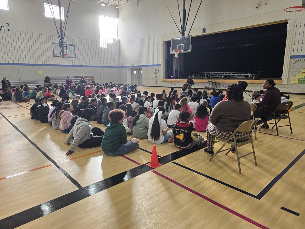 students watching an African storyteller in a gym