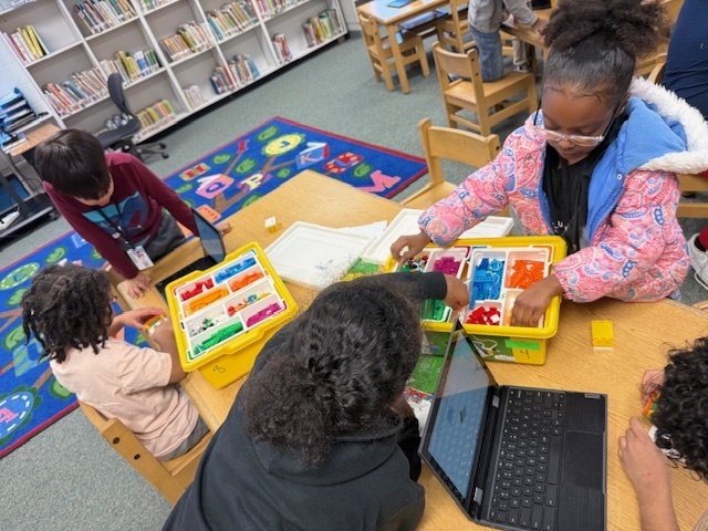 Students using LEGO Spike kits; Happy Traveler
