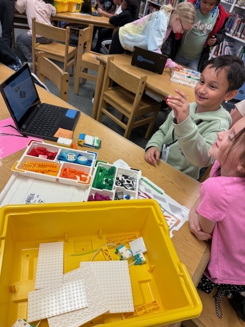 Students using LEGO Spike kits; Happy Traveler