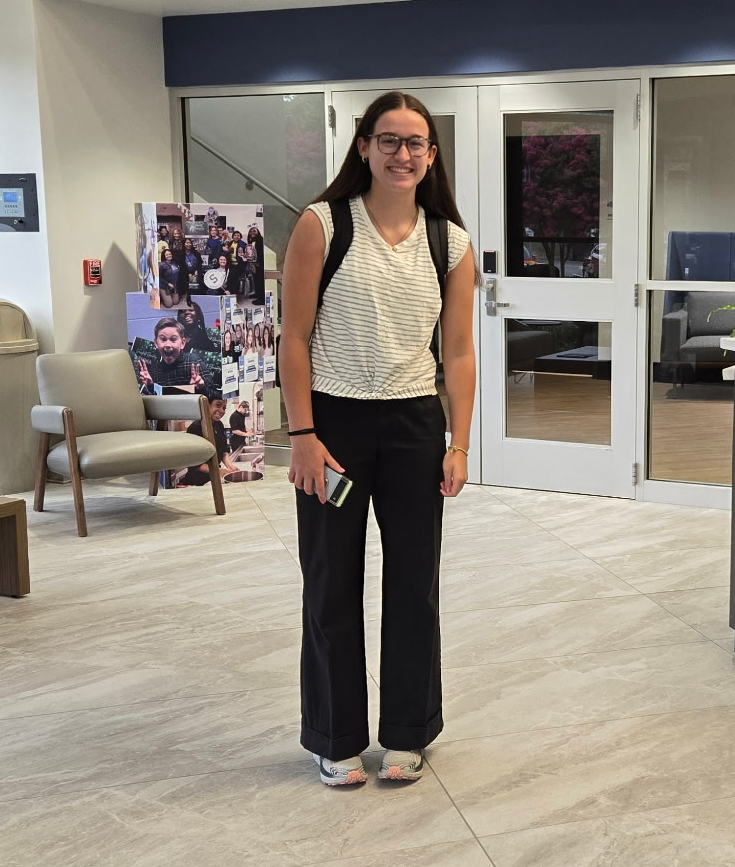 Marcy standing in lobby smiling.