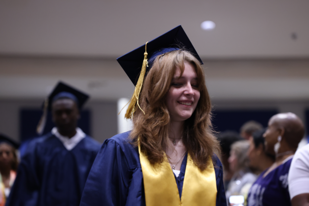Graduate walking down row.
