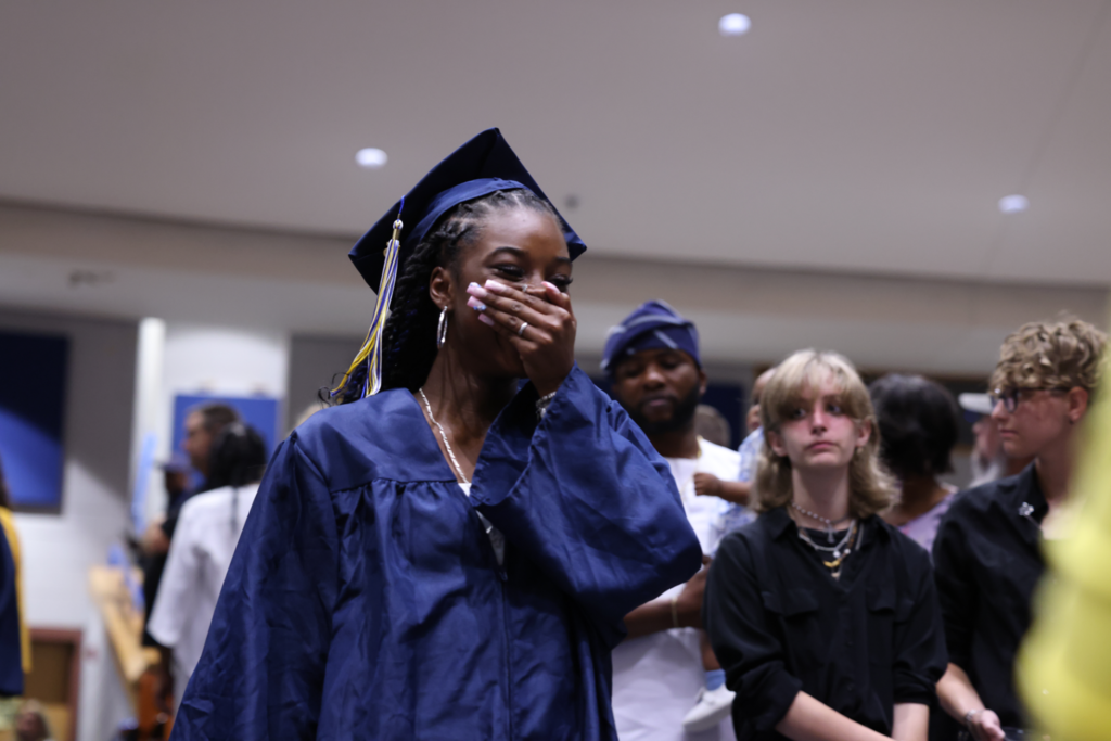 Graduate walking down row.