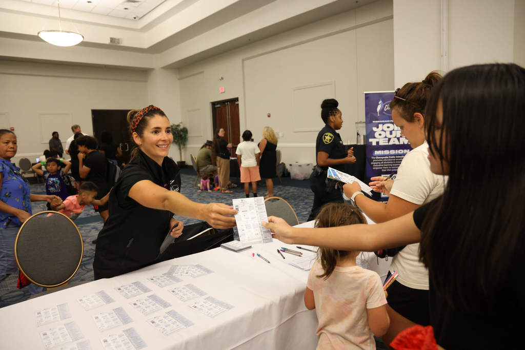 Staff handing out school calendar to students