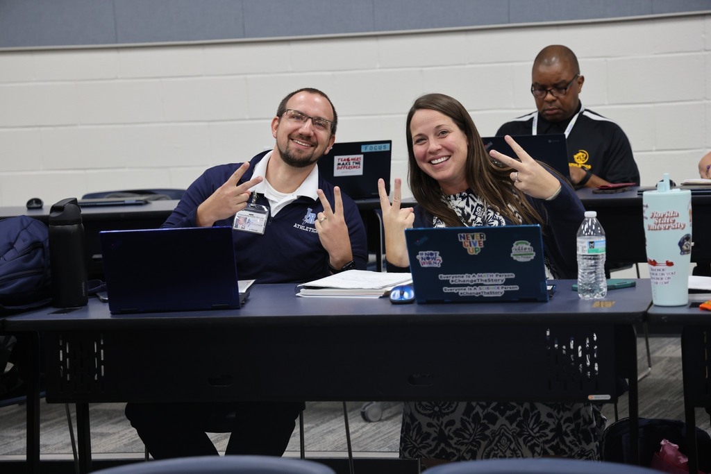 2 admins smiling with peace signs