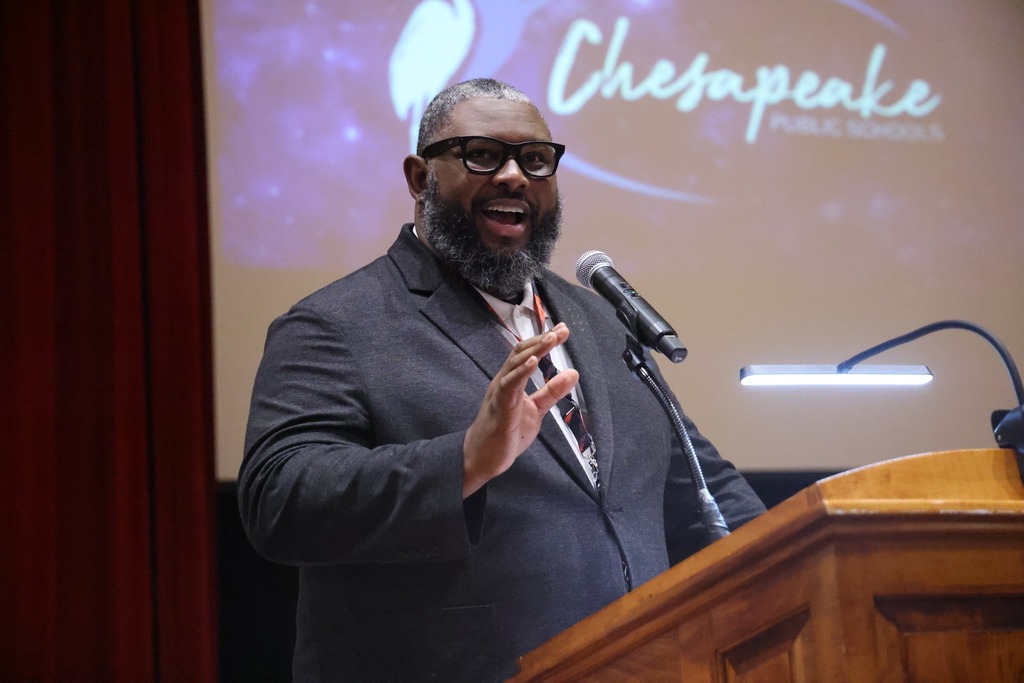 Man speaking and smiling at podium