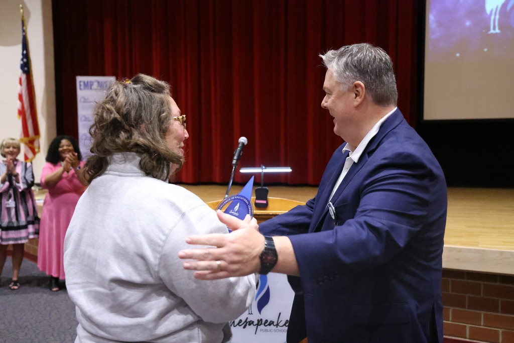 female principal receiving award from superindent