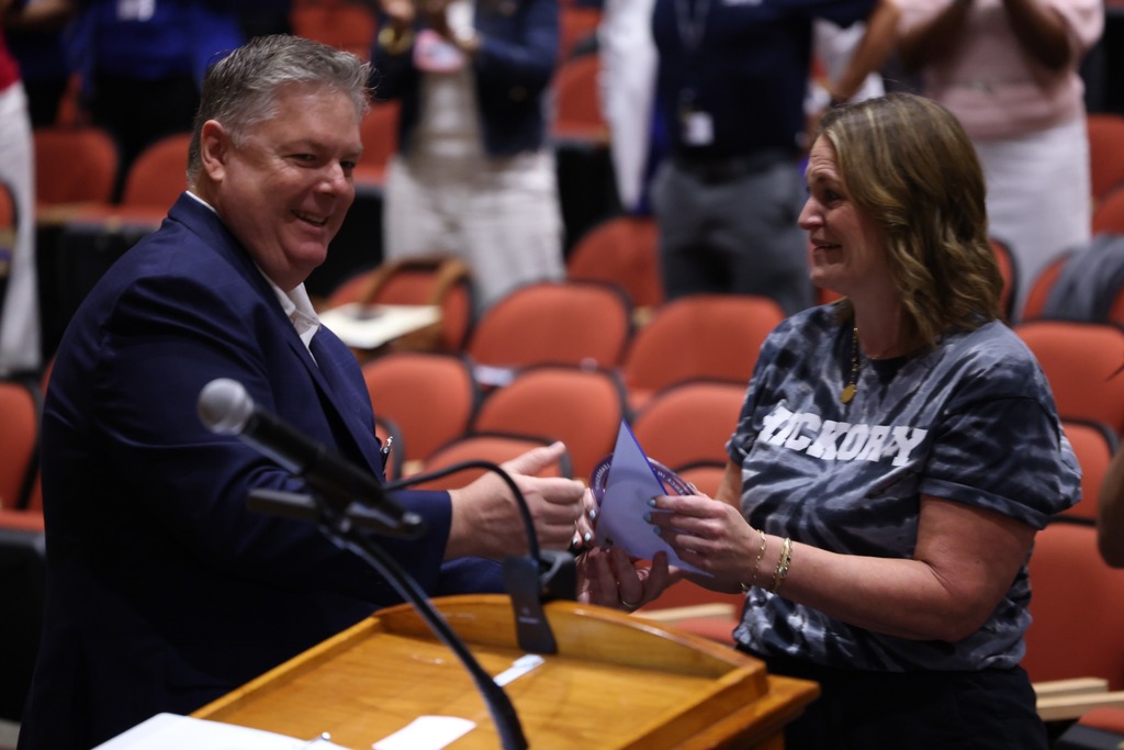 female principal receiving award from superindendent