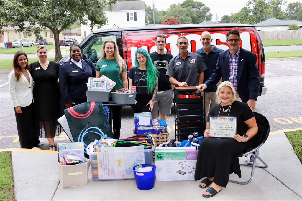 Ms. Warner, Mr. Triolet, and sponsors with award and supplies.