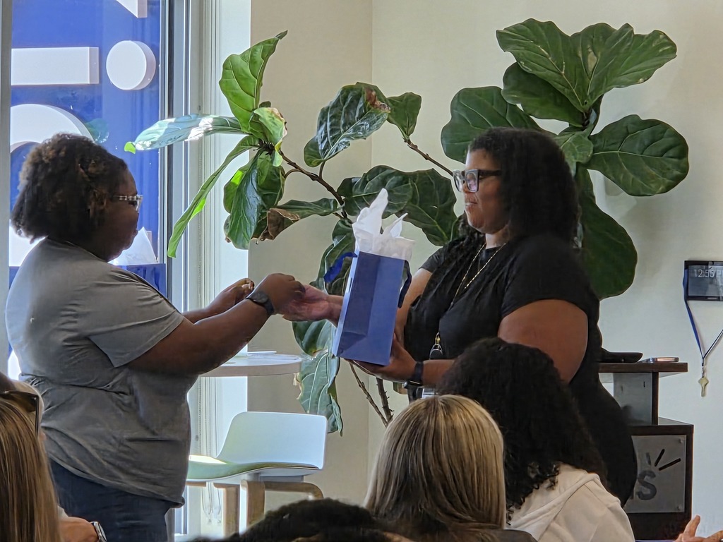 Ms. Butte receiving prize from ForKids Representative.