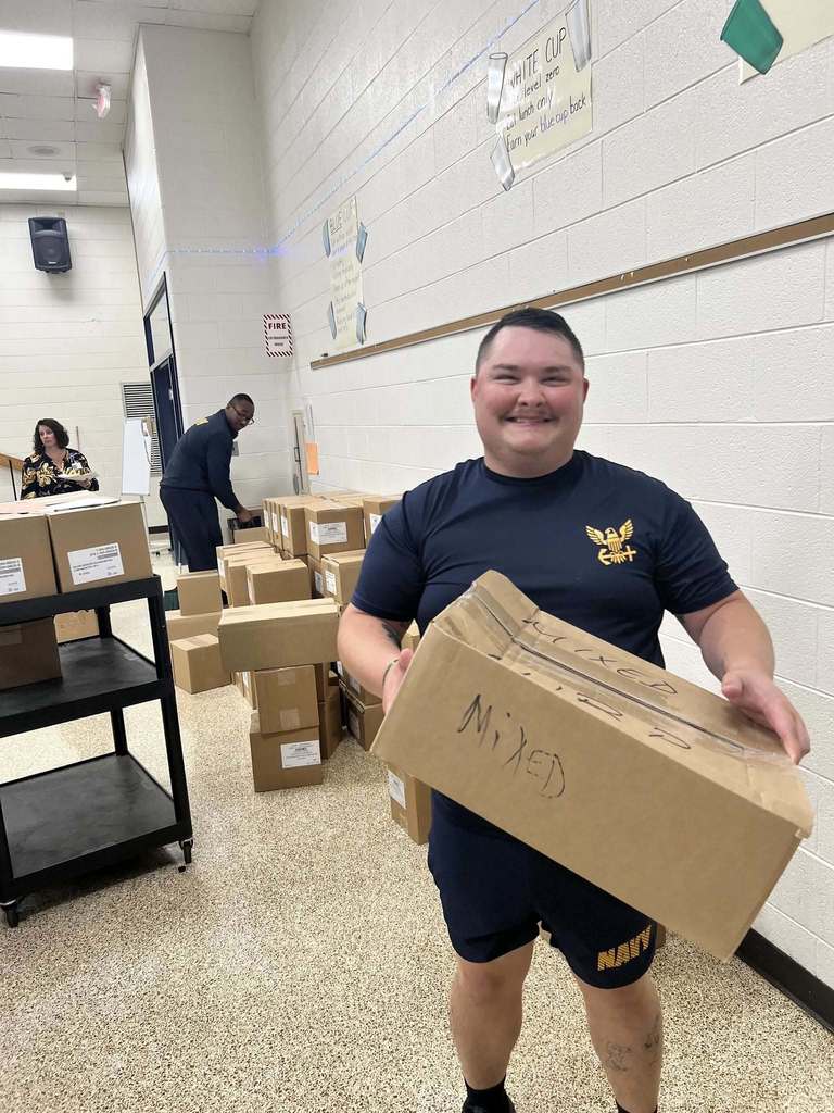 Navy volunteer carrying a box.