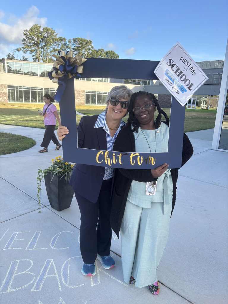 Teachers smiling holding our first day of school sign!