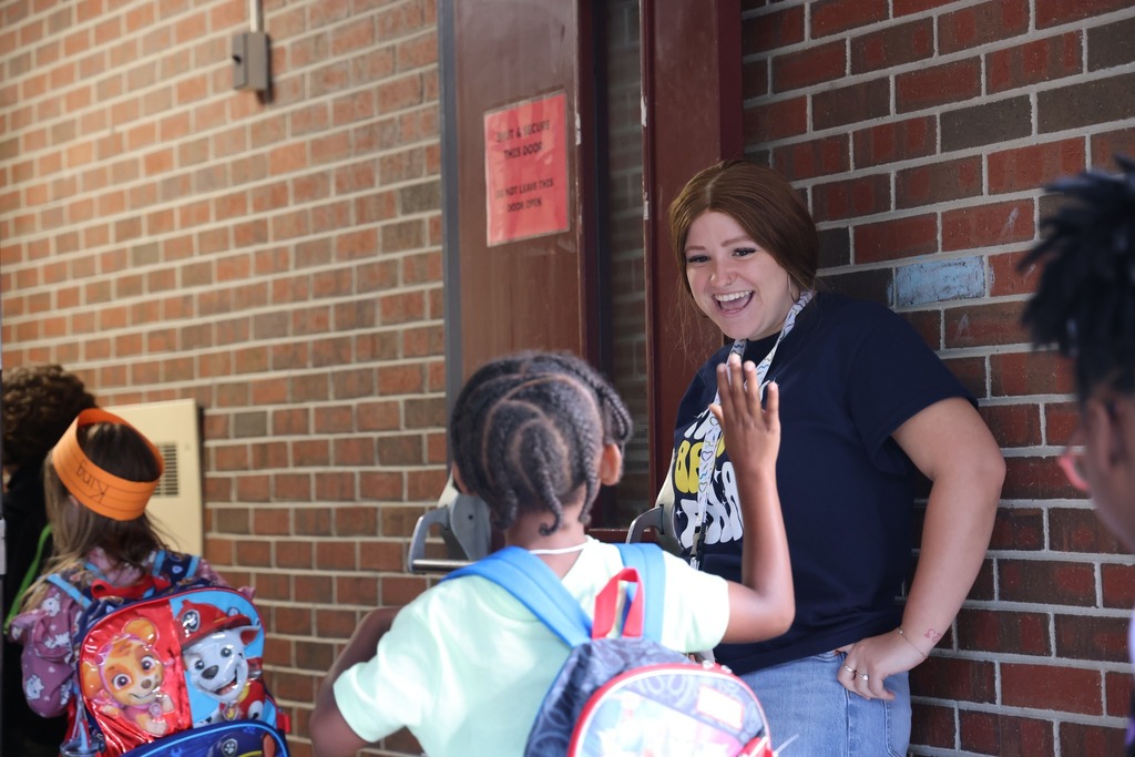 teacher smiling and high fiving a student